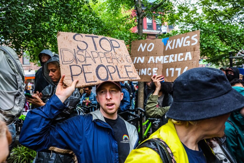 Man holds up sign that says "We the people"